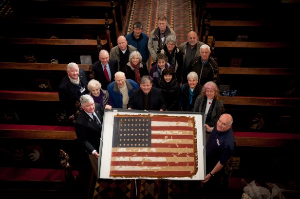The Dean of Derry, Very Rev Dr William Morton, centre, with Col Dave Wall, USMC Retd, left and Mark Lusby, Volunteer Researcher, Base One Museum at Beech Hill, right,  hold the United States Ensign from the WWII US Naval Operating Base in Derry. Col Walls is currently leading a group of former US Marines and their families on a tour of Ireland, organised by Military Historical Tours of Woodbridge, Virginia. The group took time out of their tour to visit, appropriately on the 70th anniversary of Victory in Europe Day,  the Base One Europe Museum at the Beech Hill Country House Hotel. At St Columb's Cathedral, Military Historical Tours made a donation of $400 towards the cost of having the WWII US Ensign conserved and displayed in time for the 70th anniversary of its presentation to the Cathedral in November 1945.  PHOTOCREDIT Stephen Latimer 